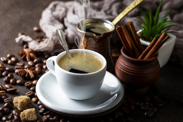 Kaffee in einer Tasse und Untertasse auf einem schwarzen Hintergrund