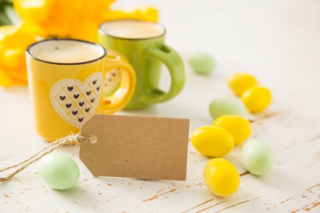 Kaffee in grünen und gelben Tassen, Tulpen