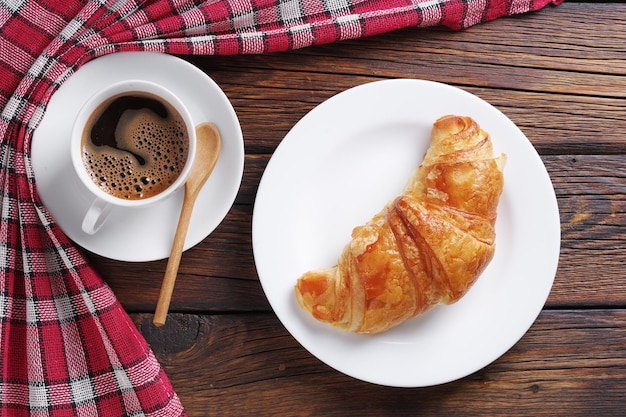 Kaffee in Tasse und Croissant