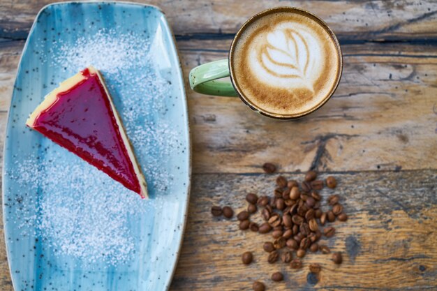 Kaffee, Kaffeebohnen und Käsekuchen auf einem Tisch