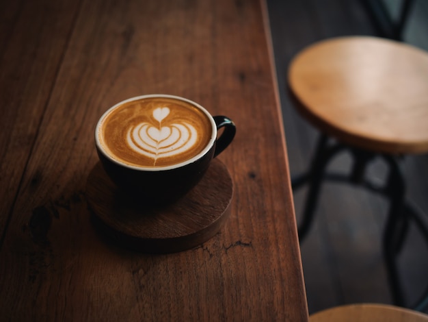 Kaffee Latte auf dem hölzernen Schreibtisch im Café