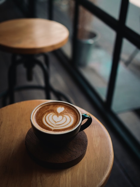 Kaffee Latte auf dem hölzernen Schreibtisch im Café