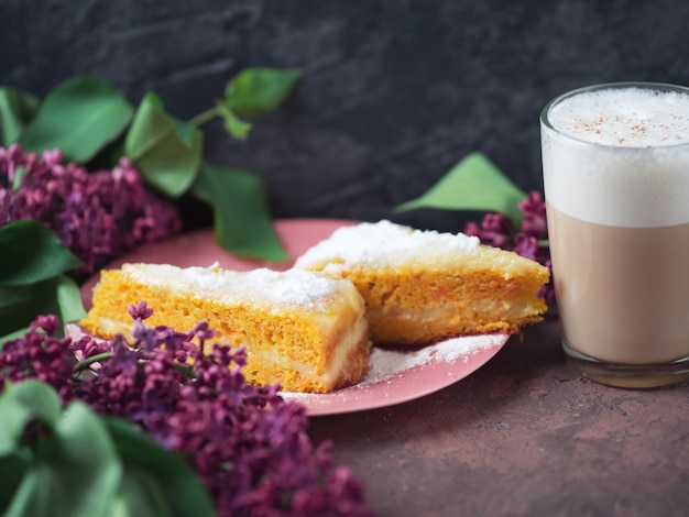 Kaffee Latte in einem Glas Glas Glas Glas mit einem Stück Kuchen