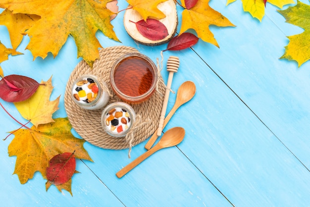 Kaffee mit Joghurt auf dem Tisch mit Herbstlaub