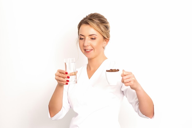 Kaffee mit Wasser die Ernährungsberaterin hält eine Tasse Kaffeebohnen und ein Glas Wasser in ihrem Ha