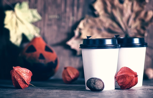 Kaffee-Pappbecher auf dem Tisch mit Kürbis