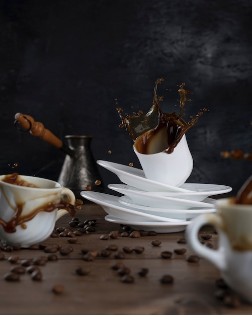 Kaffee spritzt aus tassen auf einem holztisch und schwarzem hintergrund.