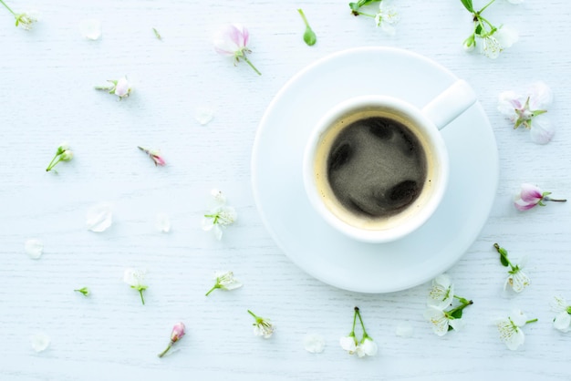 Kaffee und Blumen flach legen Draufsicht Espressotasse schwarzer Kaffee Blumenblätter weißer Schreibtischhintergrund