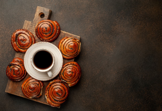 Kaffee und Brötchen mit Mohn auf einem Steinhintergrund mit Kopierraum für Ihren Text