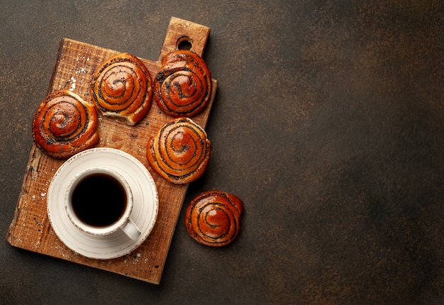 Kaffee und Brötchen mit Mohn auf einem Steinhintergrund mit Kopierraum für Ihren Text