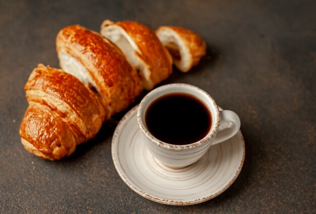 Kaffee und Croissant auf einem Steinhintergrund. leckeres Frühstück