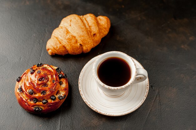 Kaffee und Croissant, Brötchen auf einem Steintisch. Frühstück