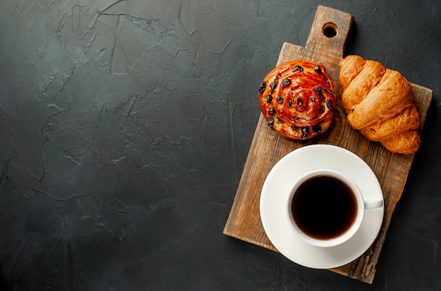 Kaffee und Croissant, Brötchen auf einem Steintisch. Morgenfrühstück mit Kopierraum für Text