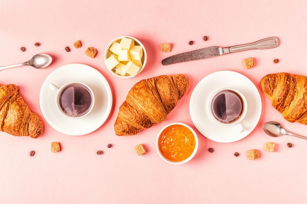 Kaffee und Croissants auf Pastell, Draufsicht.