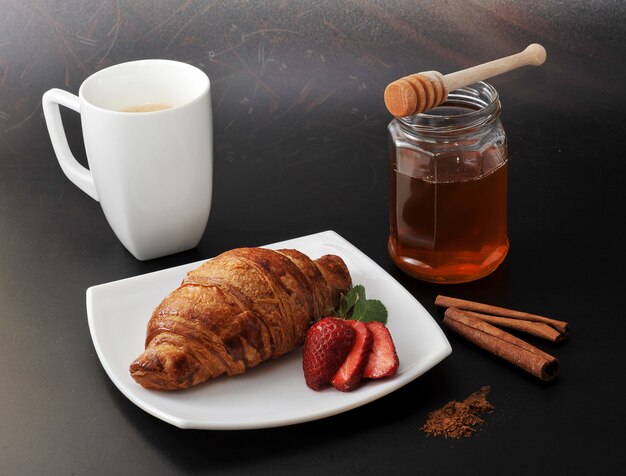 Kaffee und ein Croissant mit Erdbeeren