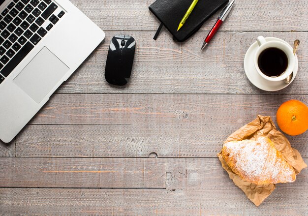 Kaffee und Hörnchen zum Frühstück, Draufsicht, hölzerner Hintergrund