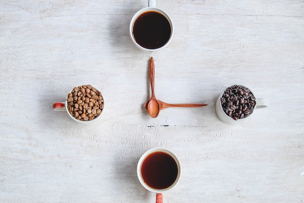 Kaffee und Kaffeebohnen gegen den weißen Hintergrund, der Borduhrkonzept bildet