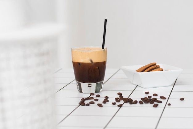 Kaffee und Kekse auf dem Boden gegen die weiße Wand