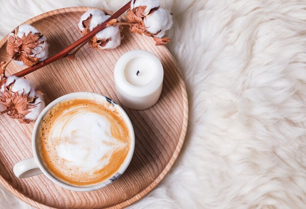 Kaffee und Kerze auf dem Holztablett