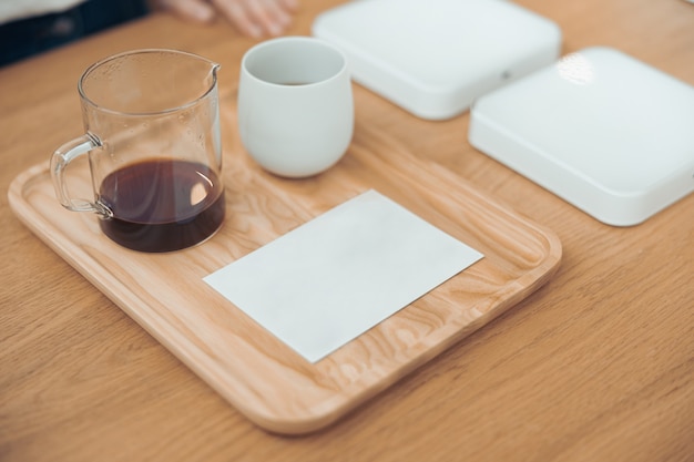 Kaffee und leeres Blatt Papier auf Holztisch