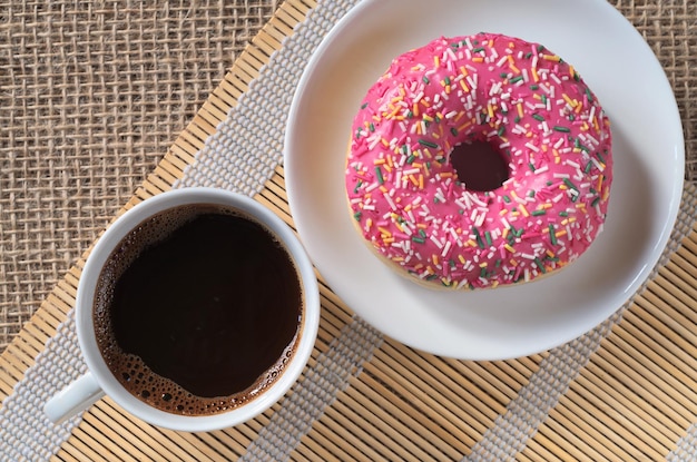 Kaffee und rosa Donut