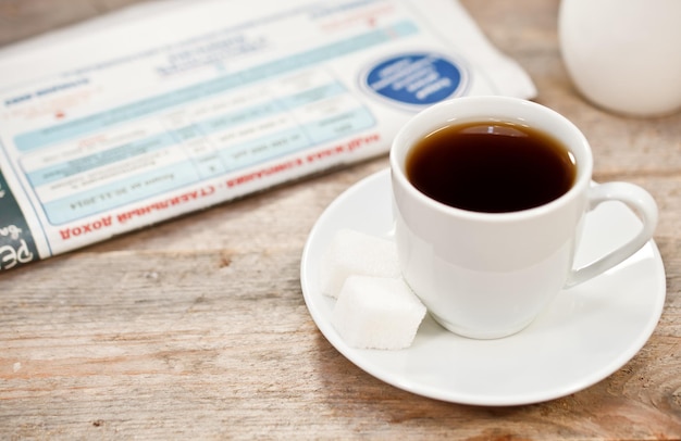 Kaffee und Zeitung auf einem Holztisch