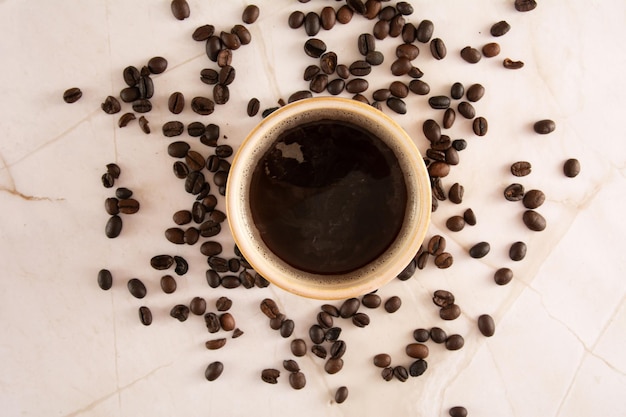 Kaffeebecher in einem marmorisierten Steinboden mit Kaffeebohnen in Marmoroberfläche in Luftansicht