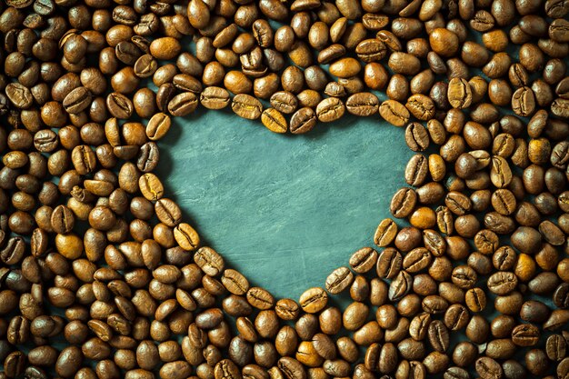 Kaffeebohne in Herzform auf Holztisch. Konzept Ich liebe Kaffee Hintergrund