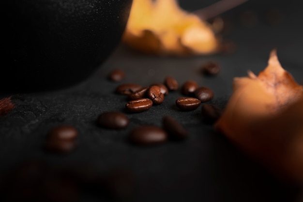 Kaffeebohnen auf dunklem Hintergrund. Herbst, Kaffeezusammensetzung. Ahornblätter. Flach liegen. . Foto in hoher Qualität