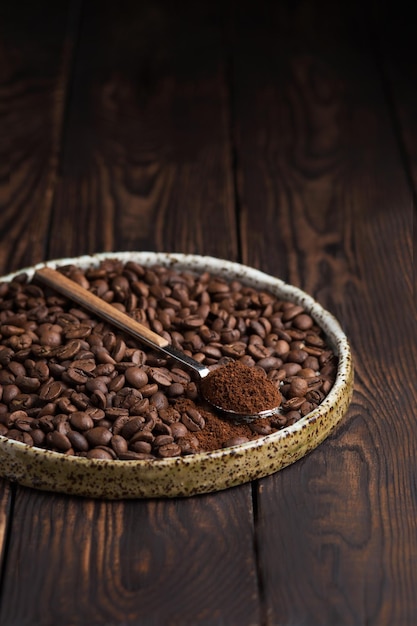 Kaffeebohnen auf einem Teller Ein Löffel mit gemahlenem Kaffee Arabica Makrofotografie in der Lebensmittelfotografie