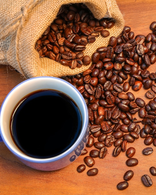 Foto kaffeebohnen auf holztisch kaffee und bohnen auf alten küchentisch.