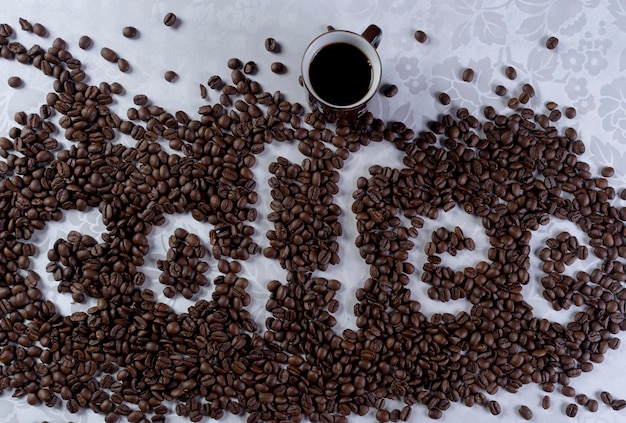 Kaffeebohnen, die das Wort Kaffee auf weißem Hintergrund bilden