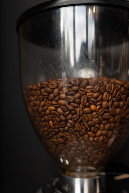 Kaffeebohnen geröstet und in eine Kaffeemühle gegossen Der Prozess der Kaffeezubereitung durch einen Barista Closeup