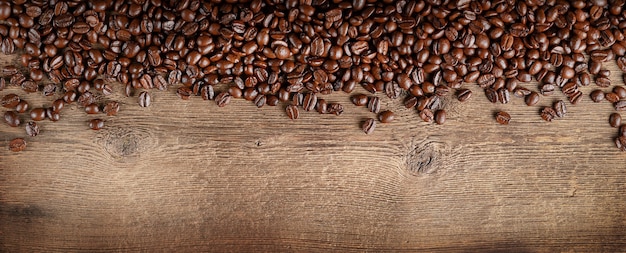 Kaffeebohnen grenzen auf dunklem Holzhintergrund. Kopieren Sie Platz, Ansicht von oben.