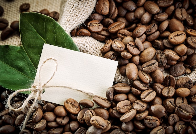 Kaffeebohnen im braunen Löffel auf Sackleinen.