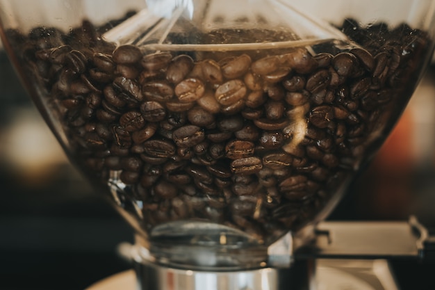 Kaffeebohnen in der Kaffeemaschine mit Weinlesefarbton.