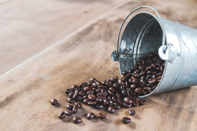 Kaffeebohnen in einer Metallwanne auf Bretterboden