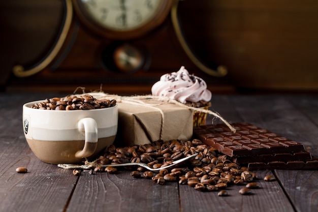 Kaffeebohnen in einer Tasse mit dunkler Schokolade