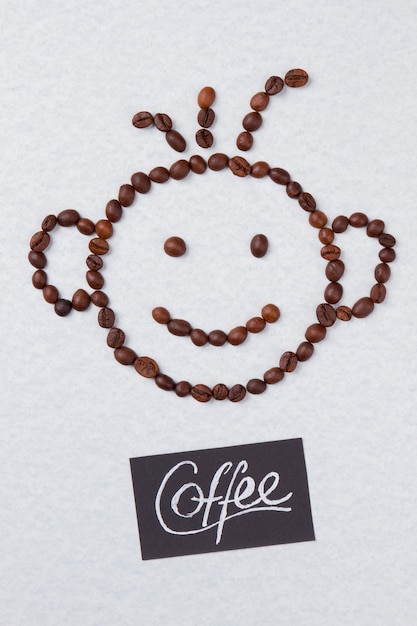 Kaffeebohnen in Form eines lächelnden Jungen angeordnet