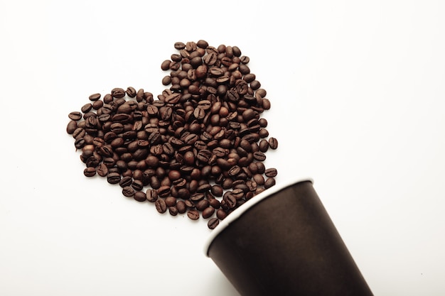 Kaffeebohnen in Form von Herzen aus der Kaffeetasse.