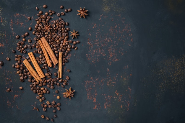 Kaffeebohnen mit Gewürzanis und -Zimtstangen auf rostigem Steinoberflächenhintergrund