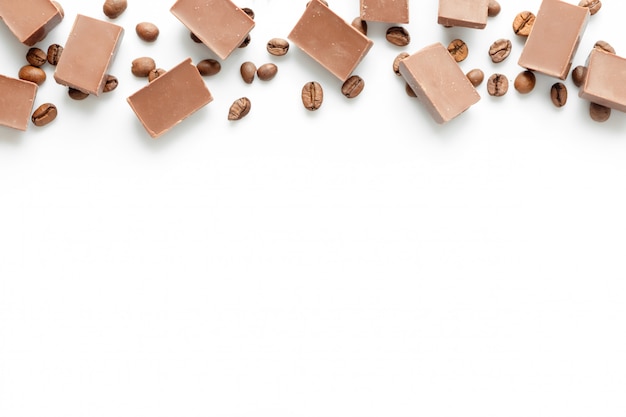 Kaffeebohnen mit Schokoladenstücken auf weißem Hintergrund kopieren Raum