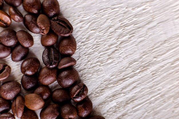 Kaffeebohnen oder Korn auf weißem hölzernem Hintergrund