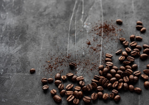 Kaffeebohnen streuten auf der grauen Hintergrundoberansicht