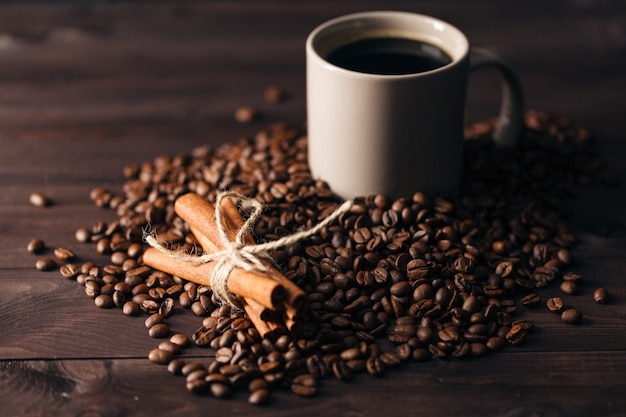 Kaffeebohnen und eine Tasse Kaffee auf dem Tisch auf dem braunen Tisch