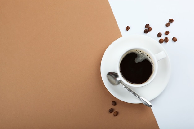 Kaffeebohnen und Kaffeetasse auf farbigem Hintergrund mit Platz für Text