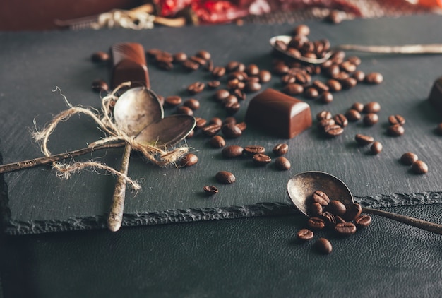 Kaffeebohnen und Süßigkeiten auf schwarzem Hintergrund