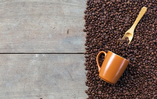 Kaffeebohnen und Tasse auf Holzbodenhintergrund. Draufsicht