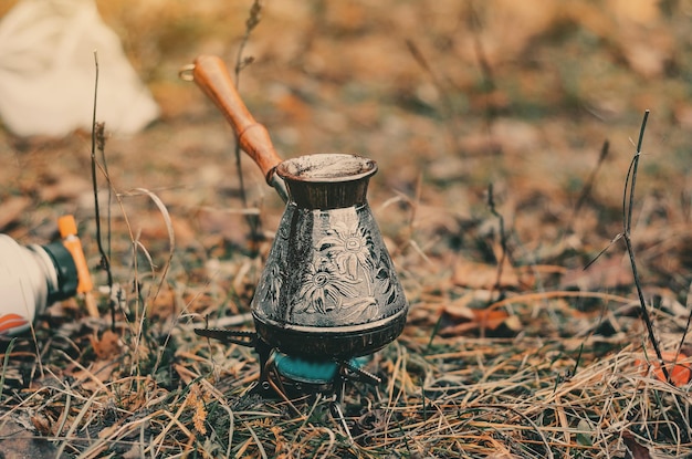 Kaffeebrühen in Metall alter Türke im Herbstwald Ruhen Sie sich außerhalb der Stadt aus