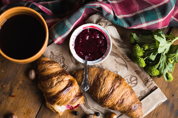 Kaffeecroissant auf altem Holztisch